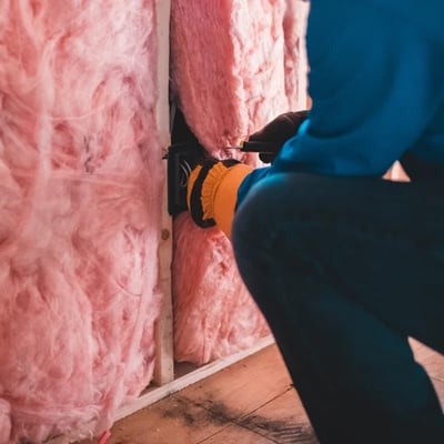 Technician installing insulation Technician installing insulation