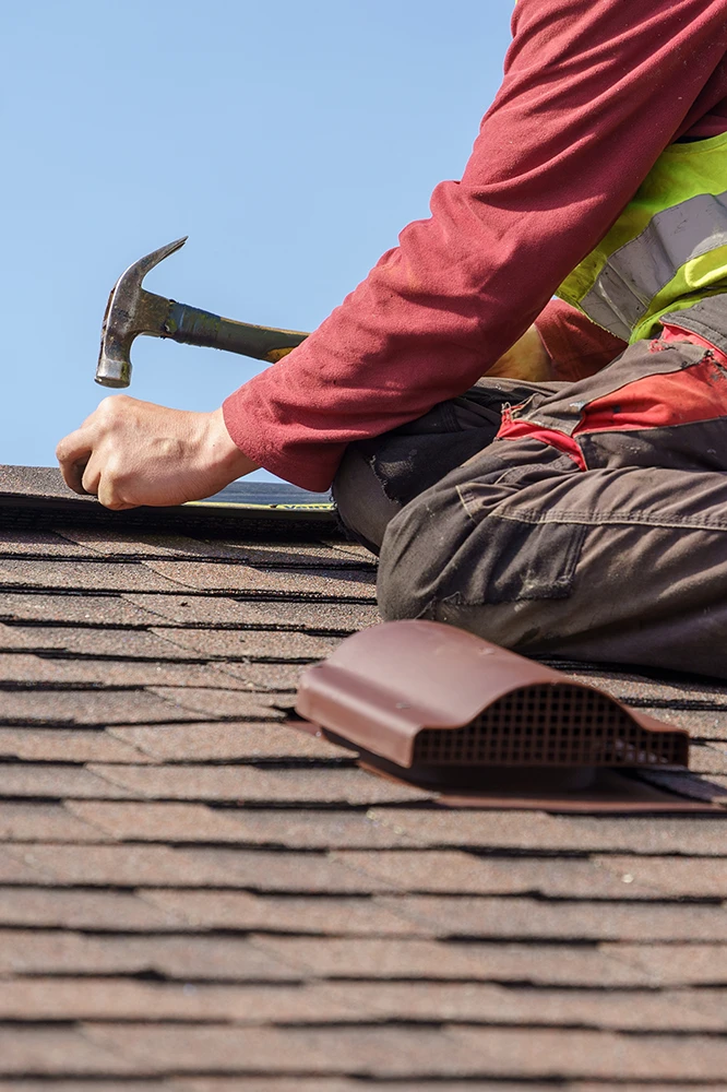 Roof repair technician working on roof